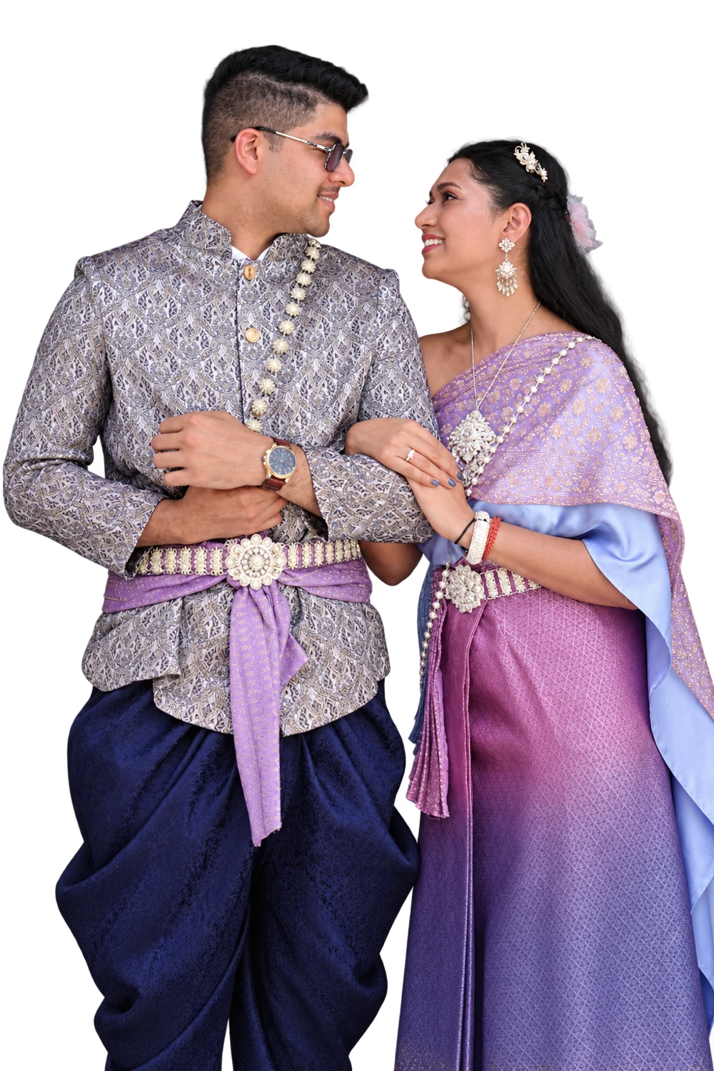 Malika and Jyanesh smiling at one another in their lavender and silver traditional outfits